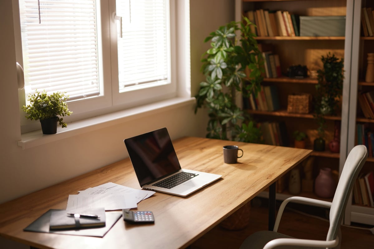 A cozy study desk with a laptop, notebooks, and a cup of coffee ready for productive work