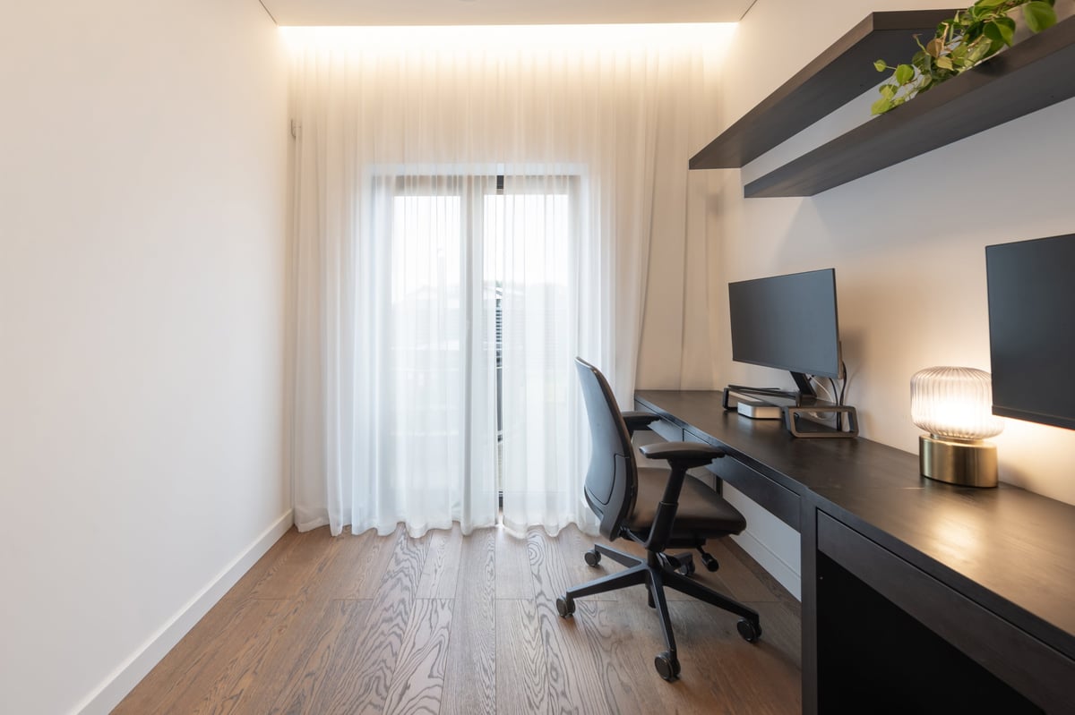 A minimal, calm home office with dual monitors, a wood desk, and soft natural light for focused work